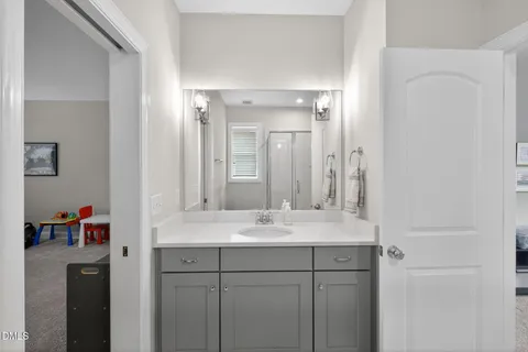 a bathroom with a double vanity sink mirror and shower