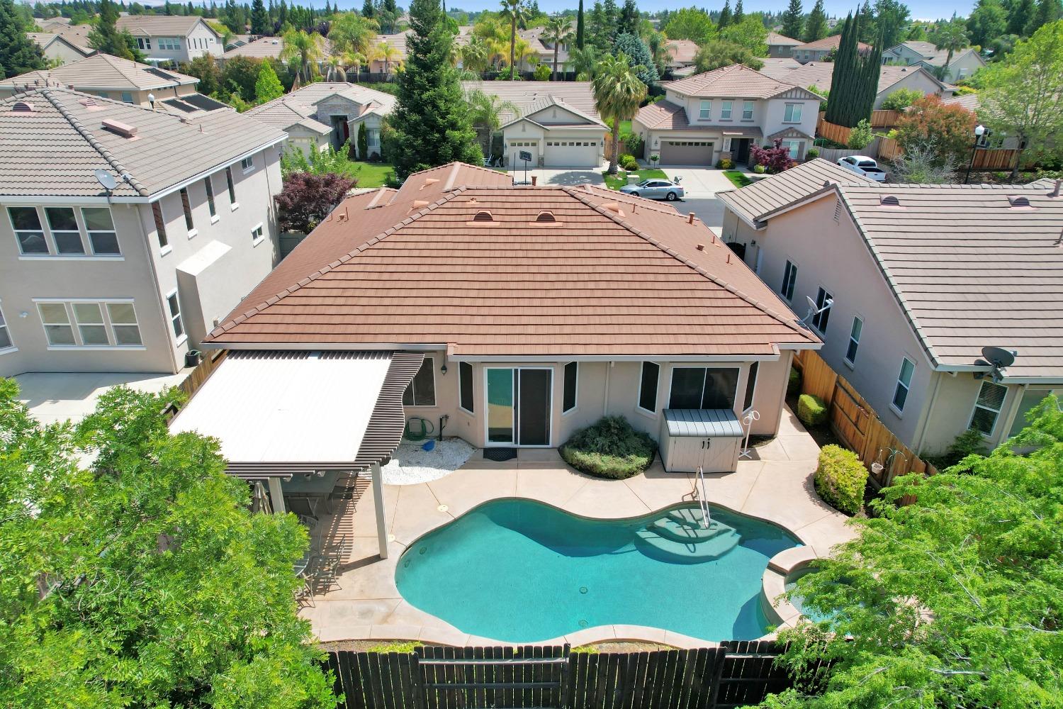 an aerial view of a house with swimming pool and patio