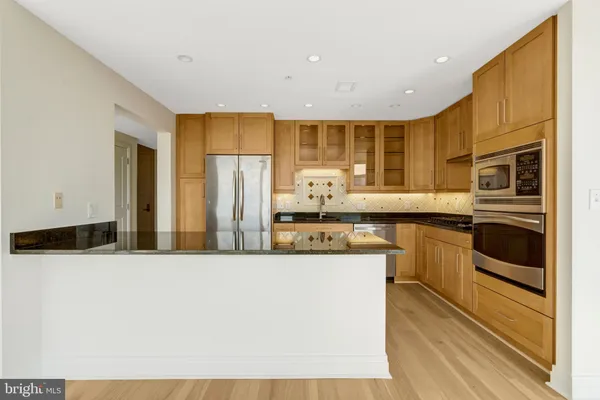 a view of open kitchen with granite countertop cabinets and wooden floor