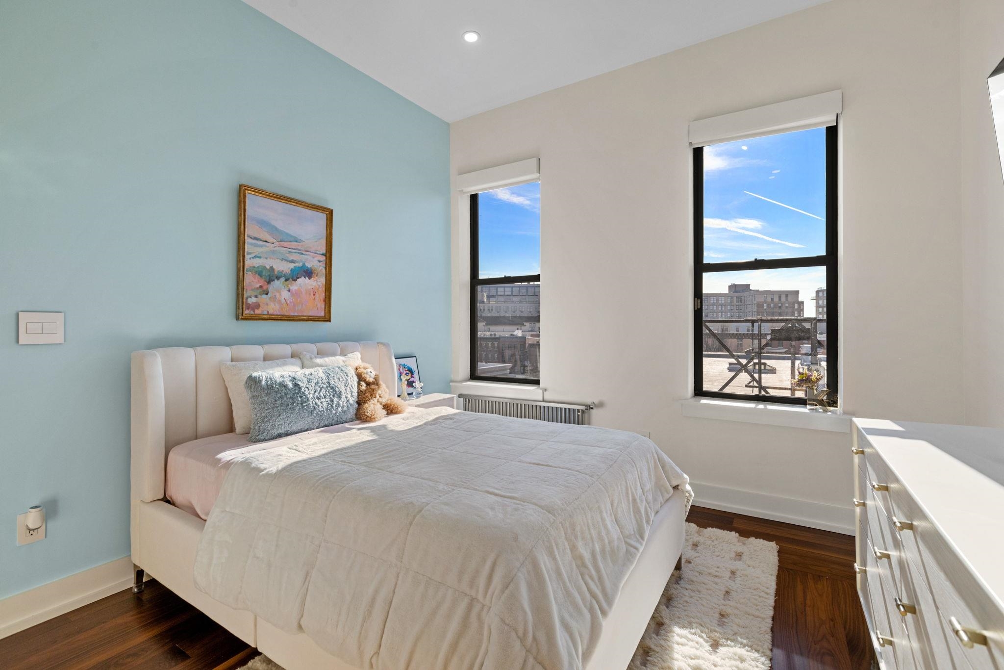 277 York Street, Unit 501 Jersey City, NJ 07302 - Photo 13 of 18 a bed sitting in a bedroom next to a window