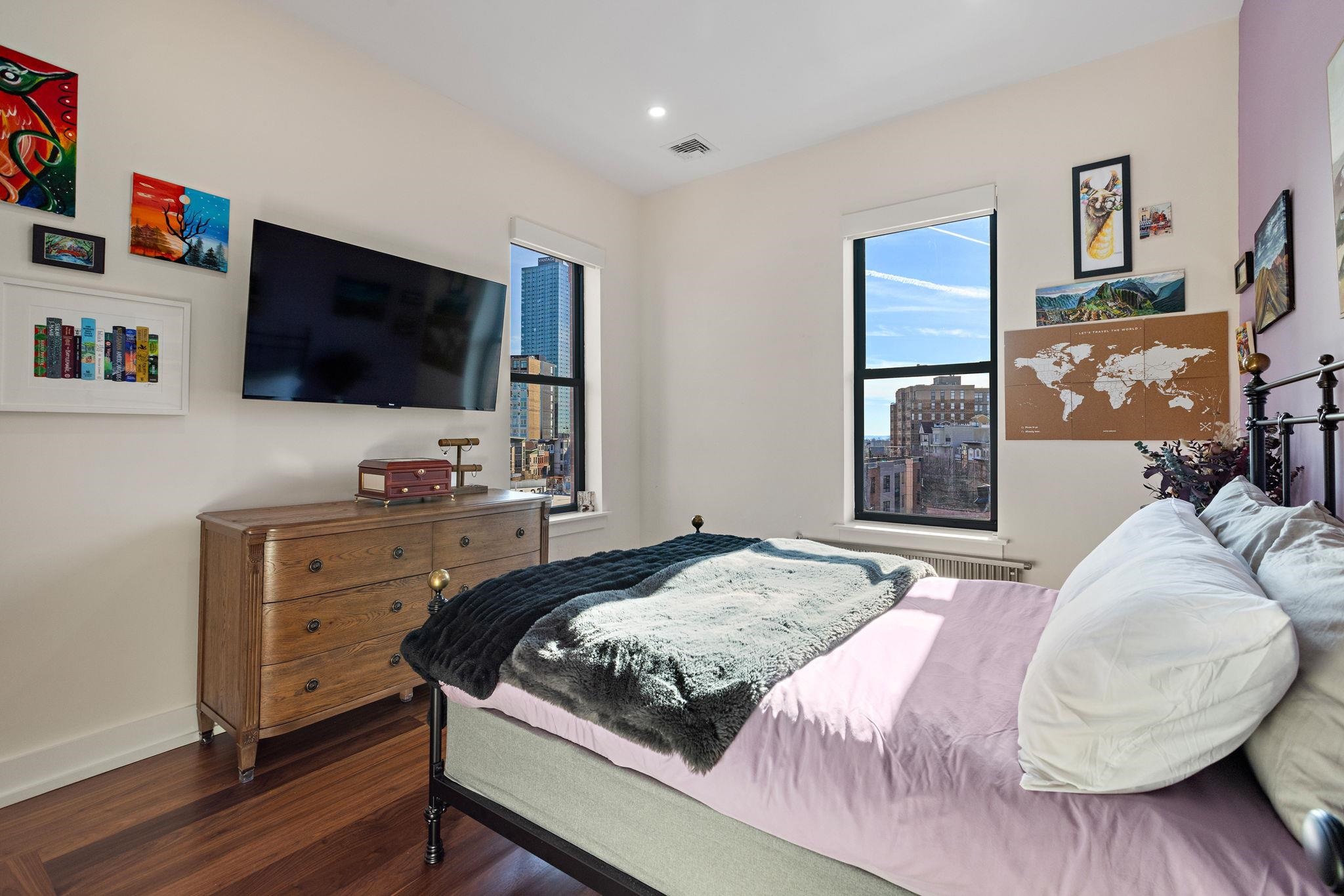 277 York Street, Unit 501 Jersey City, NJ 07302 - Photo 16 of 18 a bedroom with a bed and a flat screen tv