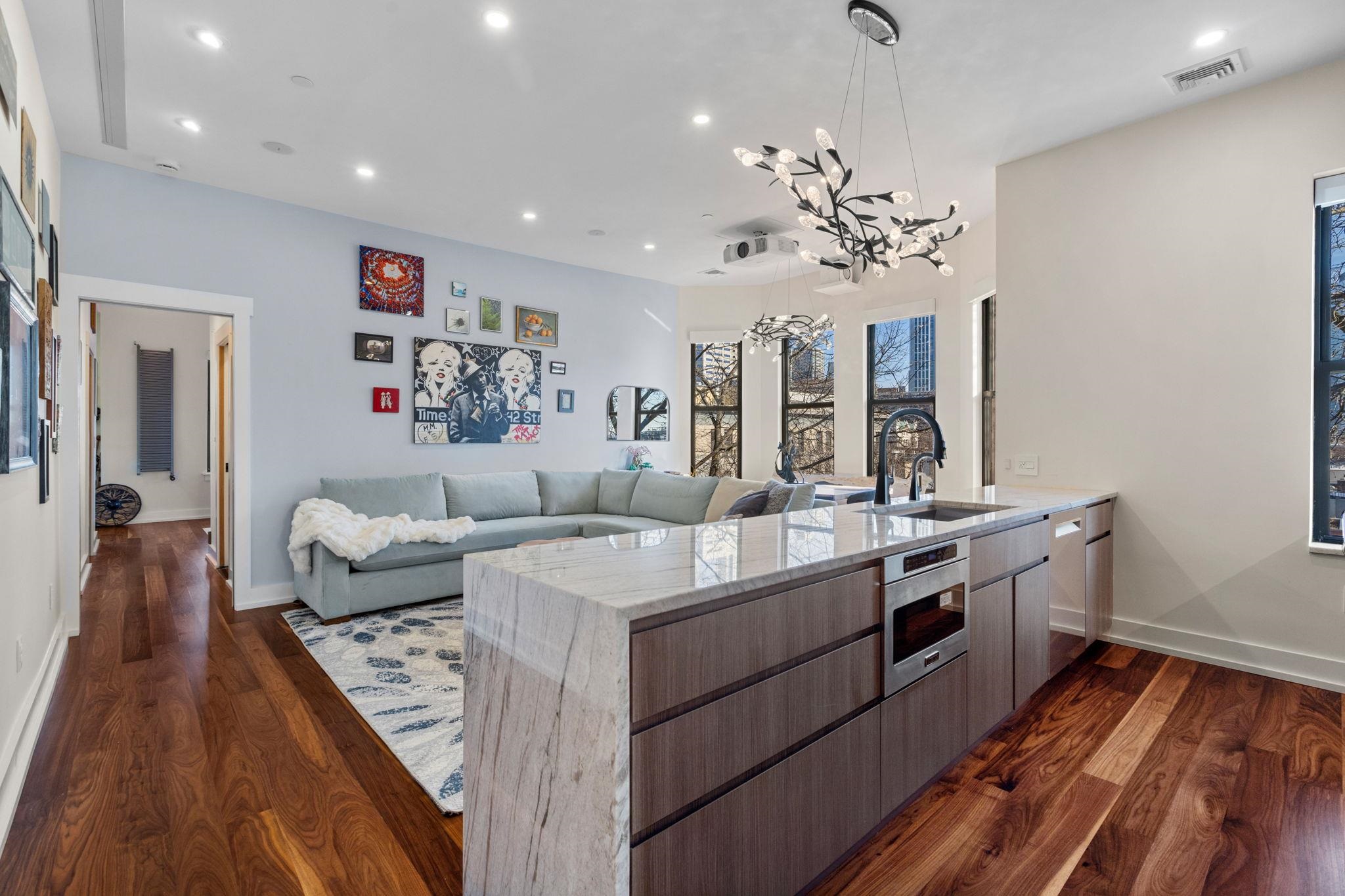 277 York Street, Unit 501 Jersey City, NJ 07302 - Photo 6 of 18 a living room with stainless steel appliances furniture a rug and a chandelier