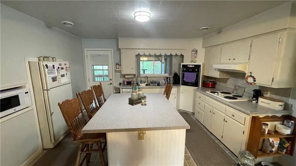 311 Kings Road Apollo, PA 15613 - Photo 6 of 11 a kitchen with stainless steel appliances granite countertop a refrigerator a stove a sink dishwasher and white cabinets with wooden floor