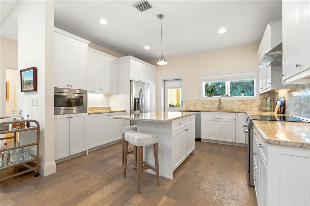 548 Conn Way Vero Beach, FL 32963 - Photo 17 of 34 a kitchen with a sink stove cabinets and wooden floor