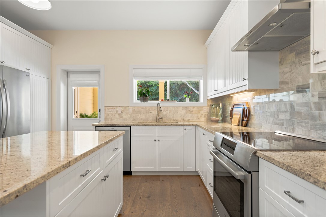 548 Conn Way Vero Beach, FL 32963 - Photo 20 of 34 a kitchen with white cabinets appliances a sink and a window