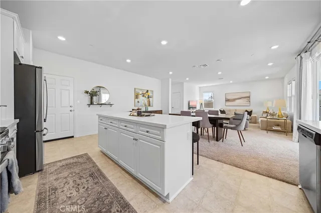 a open kitchen with stainless steel appliances kitchen island granite countertop a refrigerator and cabinets