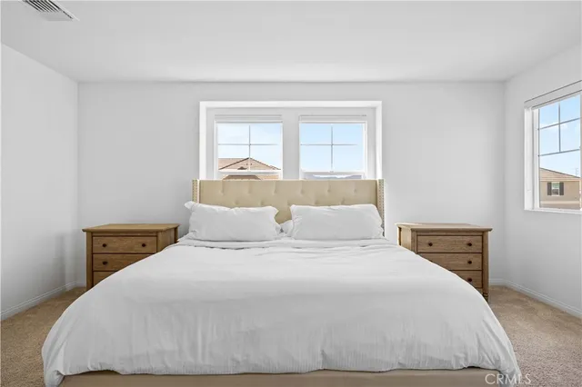 a large bed sitting in a bedroom next to a window