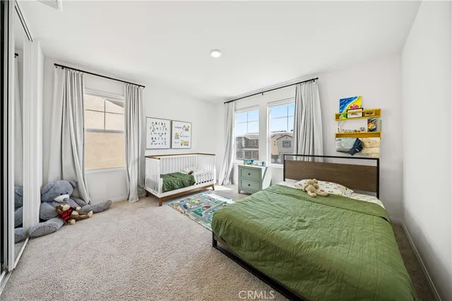 a bedroom with a bed and large windows