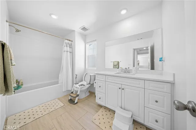a bathroom with a double vanity sink mirror and toilet