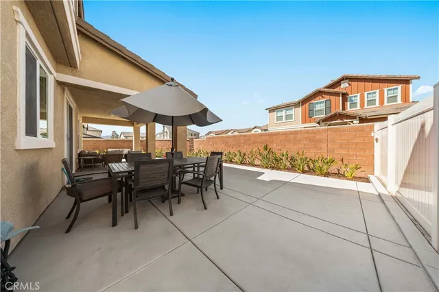 a view of a patio with table and chairs under an umbrella