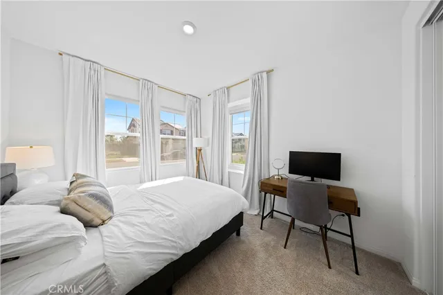 a bedroom with a bed tv and a window