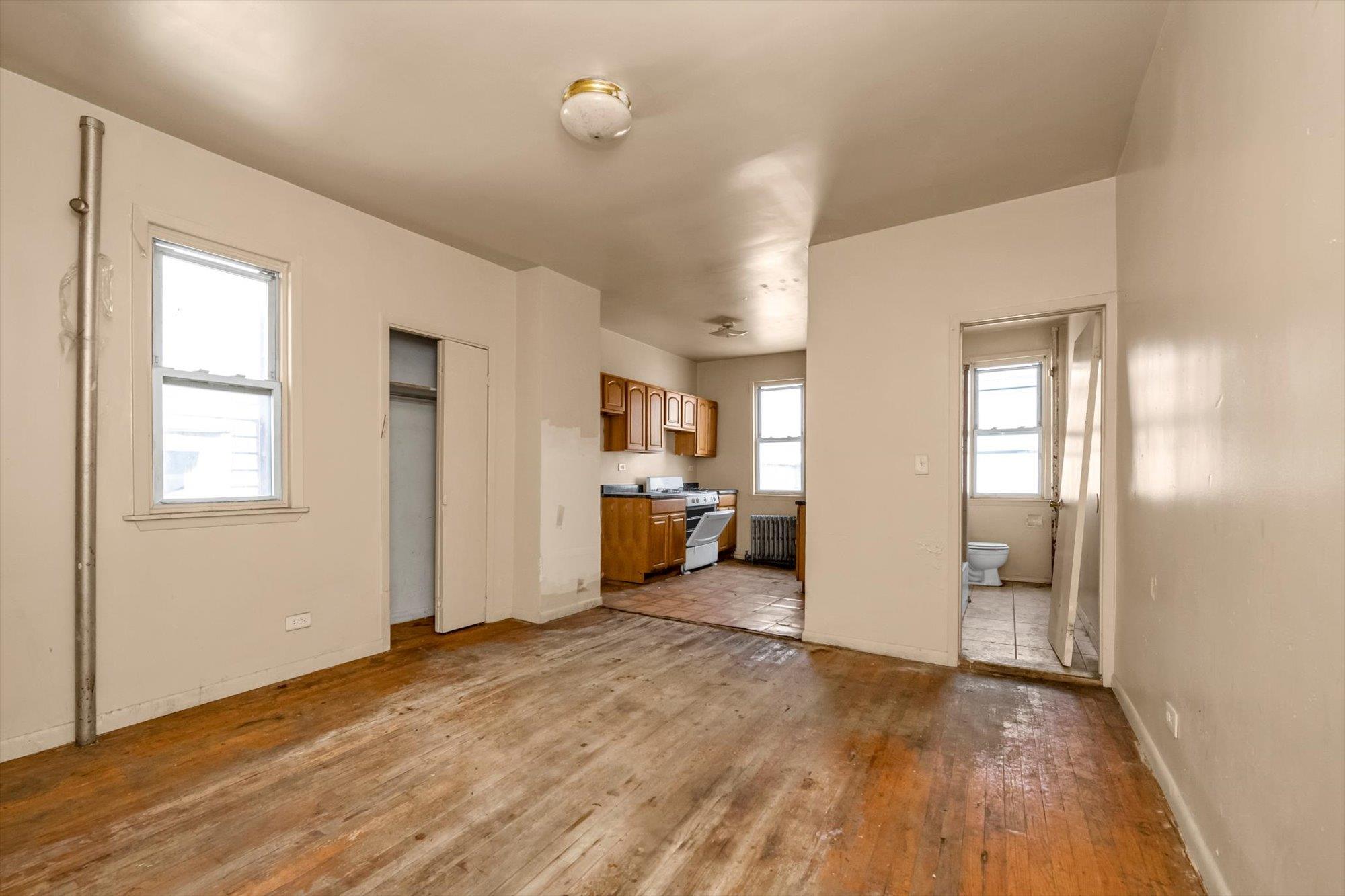 1129 East Tremont Avenue Bronx, NY 10460 - Photo 5 of 14 a view of a big room with wooden floor and windows