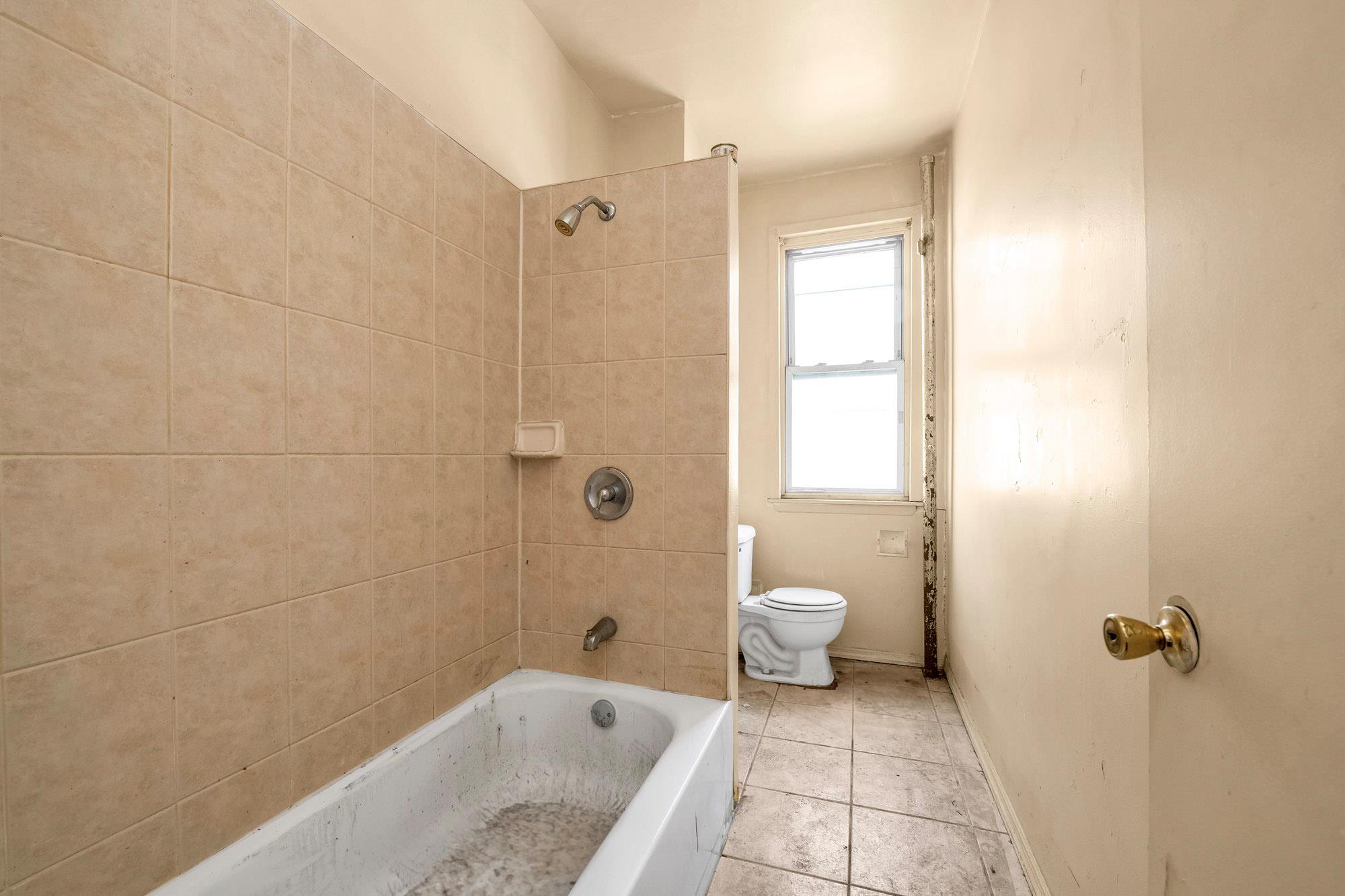 1129 East Tremont Avenue Bronx, NY 10460 - Photo 7 of 14 a bathroom with a granite countertop sink toilet and shower