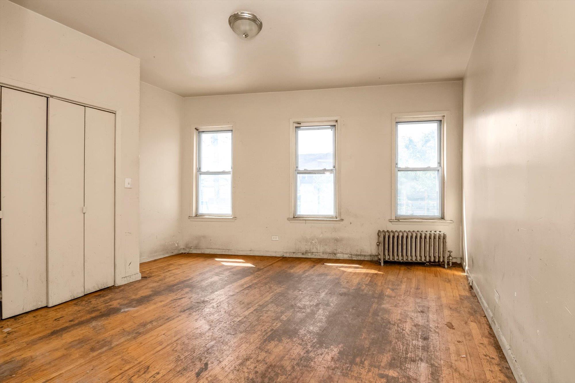 1129 East Tremont Avenue Bronx, NY 10460 - Photo 9 of 14 an empty room with wooden floor and windows