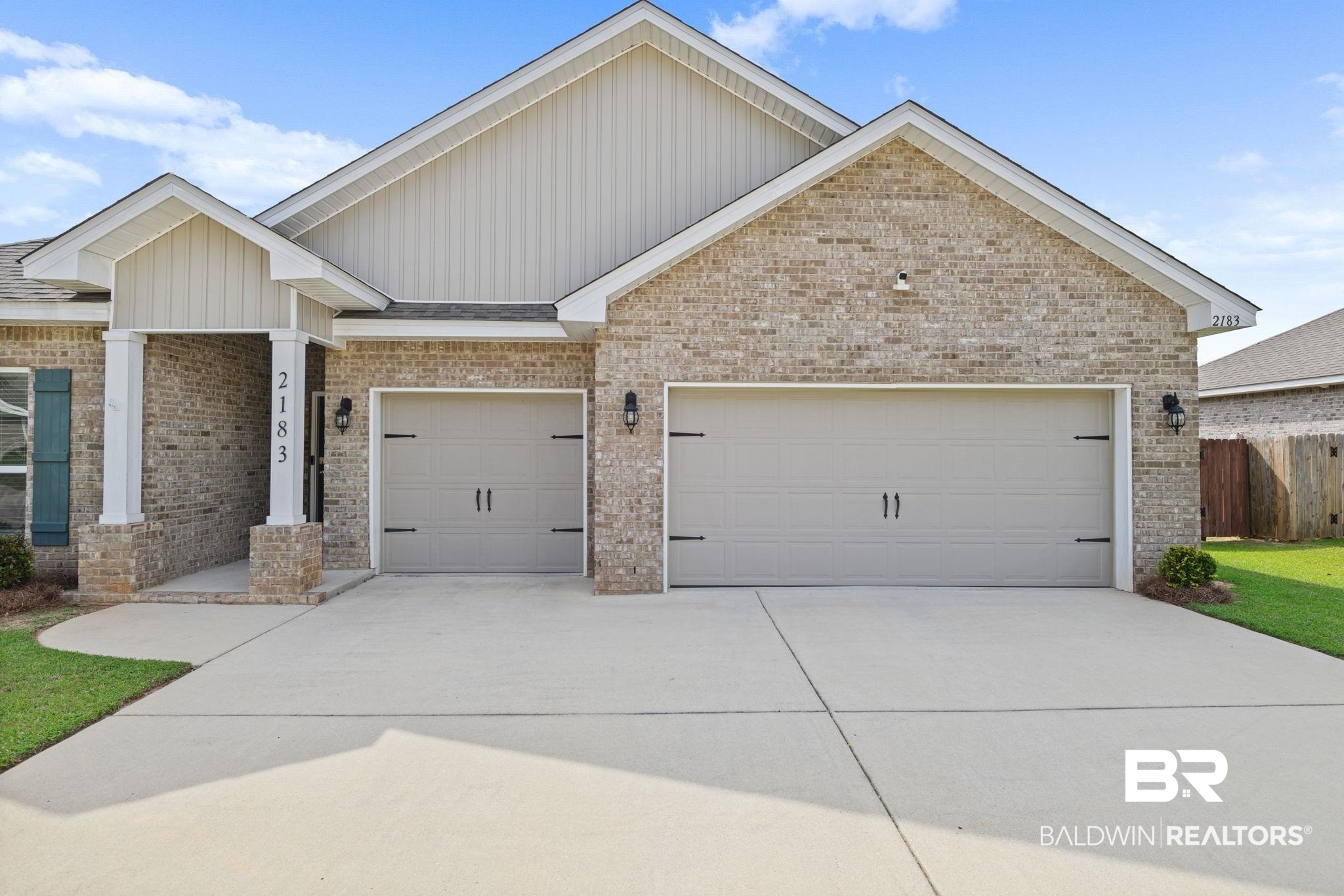 2183 Meadowview Loop Semmes, AL 36575 - Photo 6 of 58 Single story home featuring concrete driveway, an attached garage, brick siding, and board and batten siding