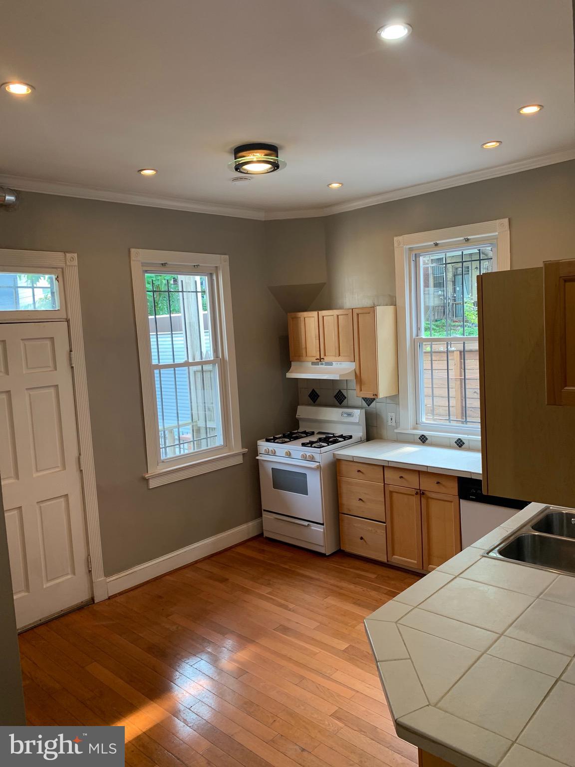 15 Seaton Place Northwest, Unit 1 Washington, DC 20001 - Photo 12 of 34 a kitchen with stainless steel appliances granite countertop a stove a sink dishwasher and a refrigerator with wooden floor