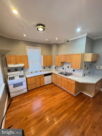 a large kitchen with kitchen island a sink stainless steel appliances and cabinets