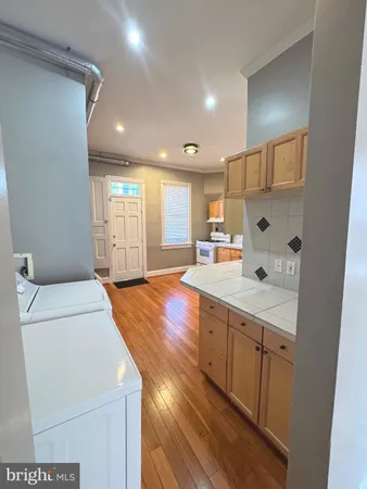 a kitchen with stainless steel appliances granite countertop a stove a sink dishwasher and a refrigerator with wooden floor