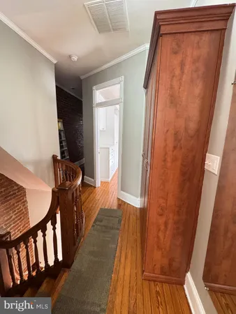 an empty room with wooden floor cabinet and a ceiling fan
