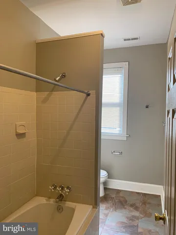 a white toilet sitting next to a bathroom sink
