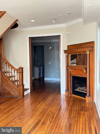 a view of a livingroom with wooden floor and a fireplace