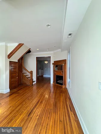 a view of empty room with wooden floor and fireplace