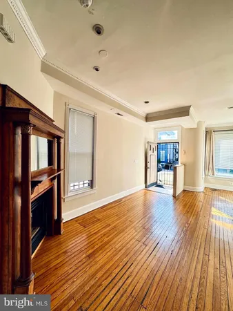 an empty room with wooden floor and chandelier