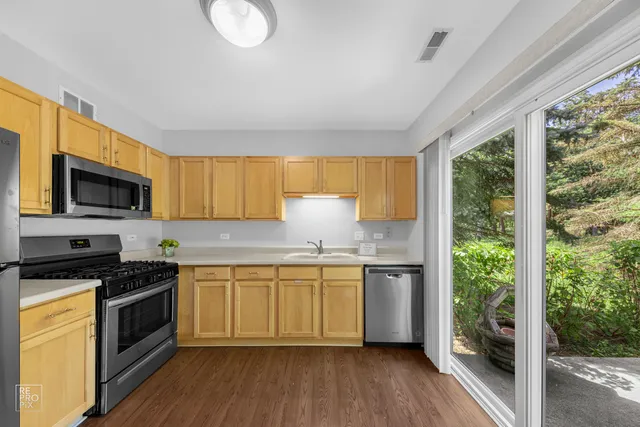 a kitchen with stainless steel appliances granite countertop a stove a sink and a refrigerator