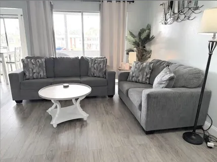 a living room with furniture a window and a table