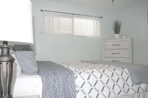 a bedroom with a bed and a painting on the wall