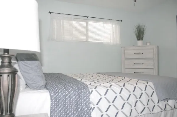 a bedroom with a bed and a painting on the wall