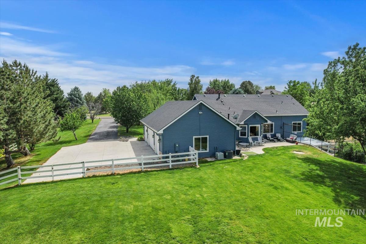 10462 West Lanktree Gulch Road Star, ID 83669 - Photo 47 of 48 Expansive property featuring a blue-sided residence with a multi-car garage, a long paved driveway, and a substantial green lawn