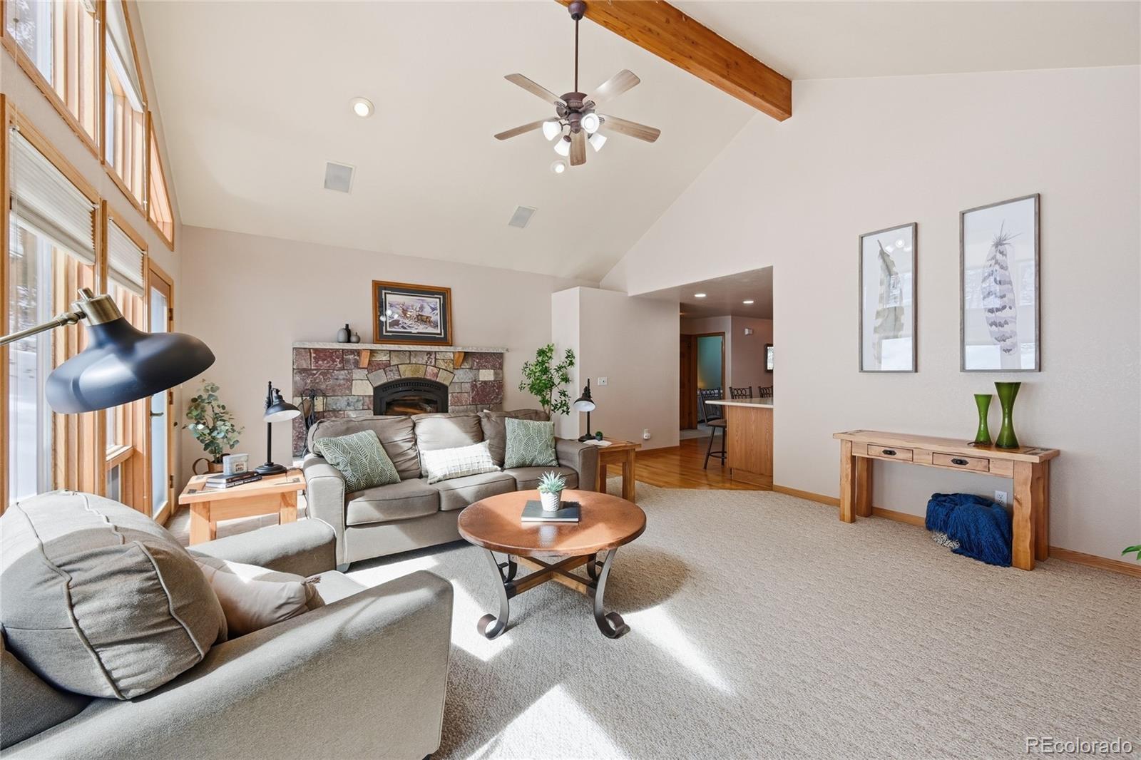 31842 Steven Way Conifer, CO 80433 - Photo 9 of 19 a living room with furniture a fireplace and a chandelier