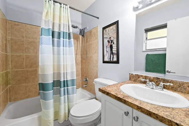 a bathroom with a granite countertop toilet a sink and a bathtub