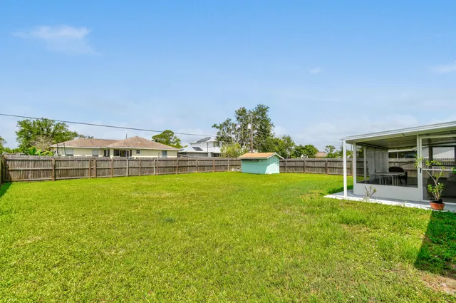 a view of a house with a big yard and potted plants