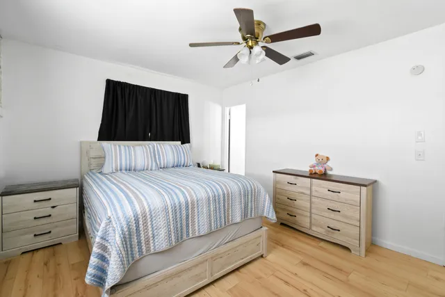 a bedroom with a bed and a ceiling fan