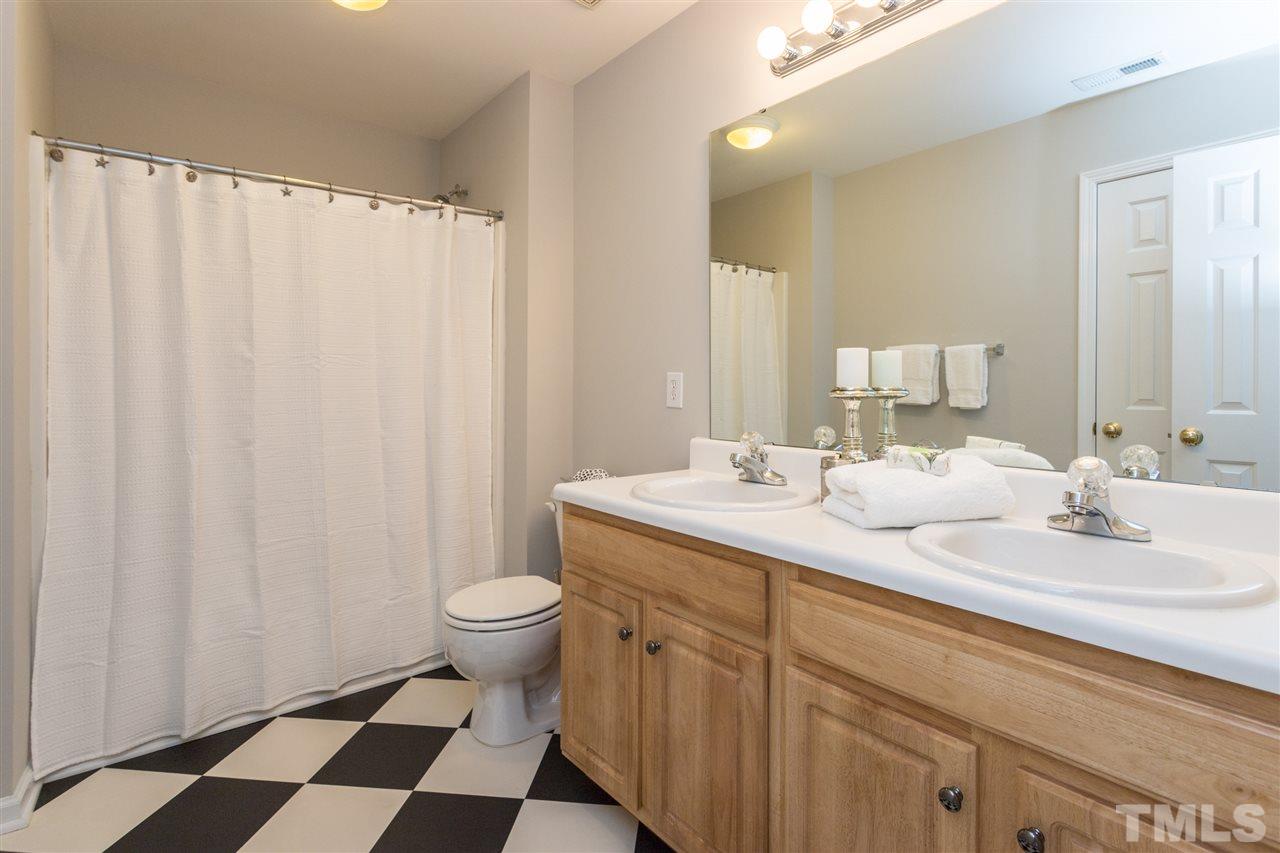 8513 Ridgebury Road Raleigh, NC 27603 - Photo 22 of 30 a bathroom with a double vanity sink toilet and a mirror