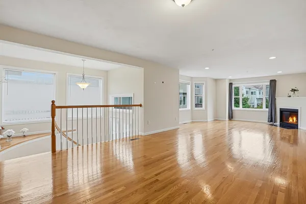 a view of empty room with wooden floor and fireplace