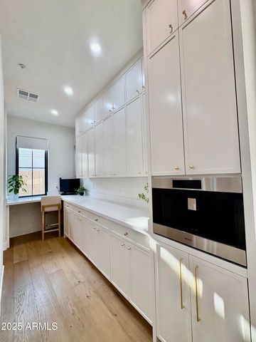 a kitchen with a stove a refrigerator a sink and white cabinets with wooden floor