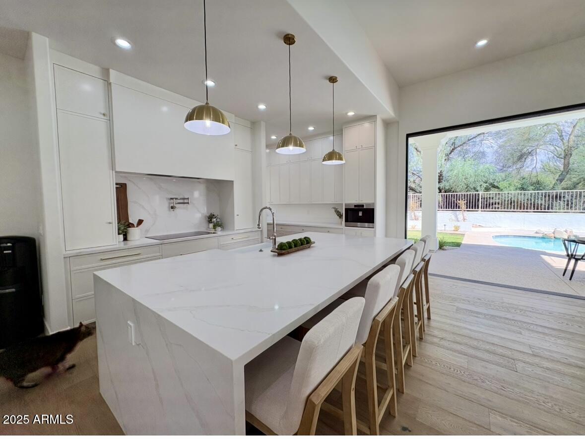 12134 East Mercer Lane Scottsdale, AZ 85259 - Photo 14 of 35 a kitchen with a stove a refrigerator a sink and white cabinets with wooden floor