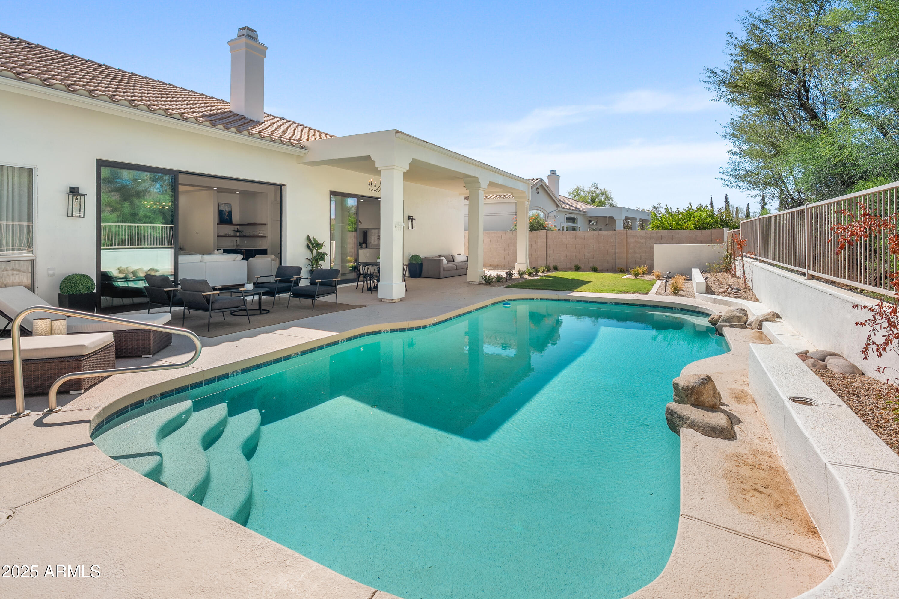 12134 East Mercer Lane Scottsdale, AZ 85259 - Photo 3 of 35 a view of a house with pool lawn chairs and a barbeque