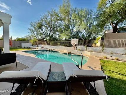 a view of a patio with table and chairs potted plants and large tree