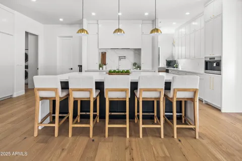 a large kitchen with kitchen island a large counter top a sink a counter space appliances and cabinets
