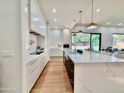 a large kitchen with granite countertop a sink and a refrigerator