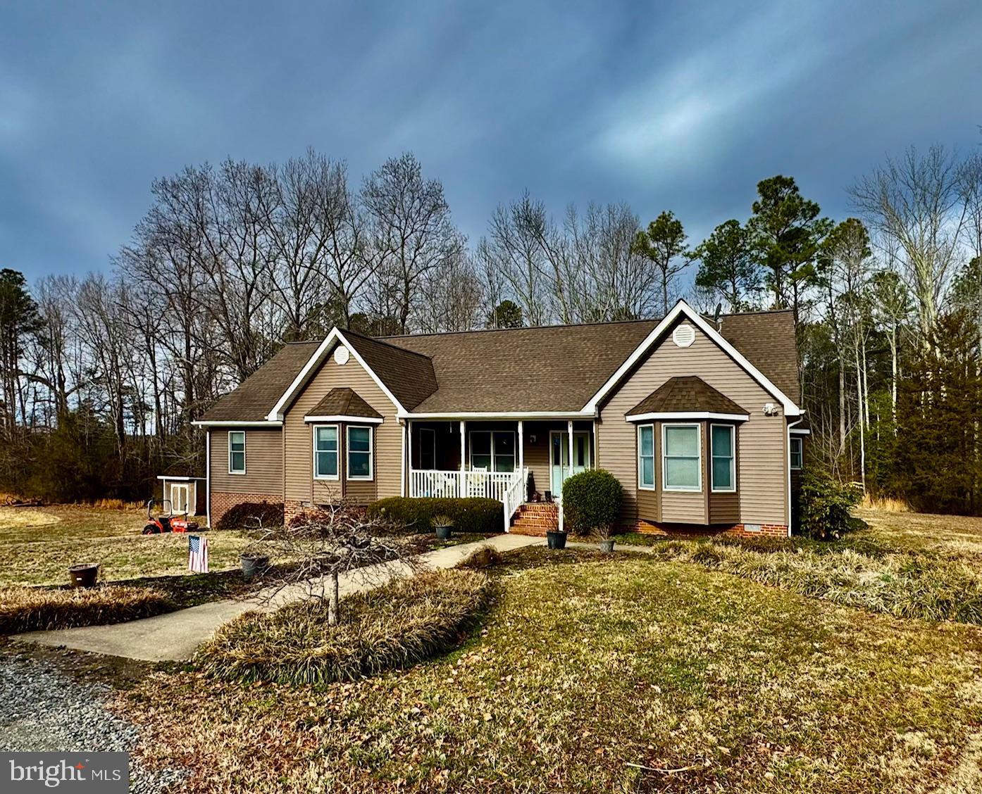 a front view of a house with a yard and large trees