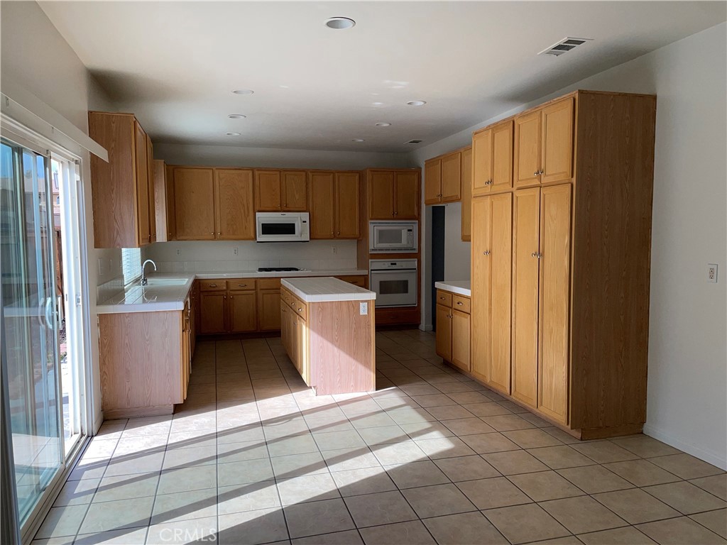 12661 Luna Road Victorville, CA 92392 - Photo 7 of 20 a kitchen with stainless steel appliances granite countertop a refrigerator a stove top oven a sink and dishwasher