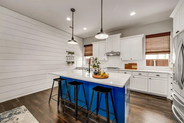 a kitchen with kitchen island granite countertop a sink a center island stainless steel appliances and furniture