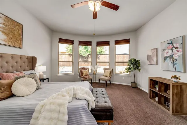 a bedroom with furniture and a large window