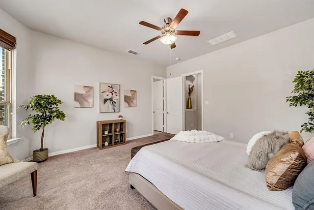a bedroom with a bed dresser and a chandelier