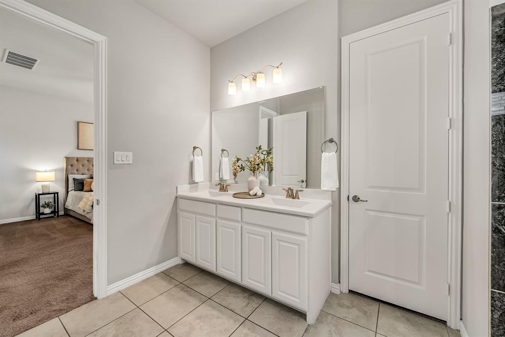 3341 Man O War Road Celina, TX 75009 - Photo 18 of 40 a bathroom with a double vanity sink and mirror